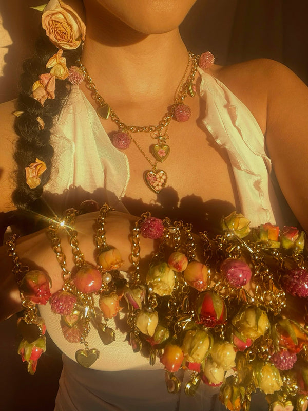Mikaela holding a handful of her preserved flower charm bracelets